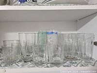 Front view of assorted clear and frosted tumblers on shelf