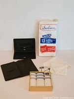 Sunlawn sealed pack, boxed striped handkerchiefs, loose white handkerchief, open black leather wallet