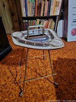 Ceramic ashtray on brass-tone stand with magazine shelf