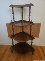 Full view of four-tier wooden corner shelf showing structure and finish
