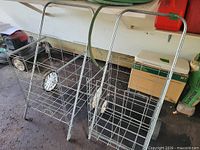 Two upright folding wire carts showing basket shape, wheels, and handles