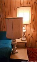 Both matching ceramic urn table lamps with shades illuminated