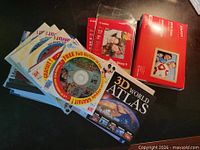 Overview showing Staples photo paper box, Canon packs, stack of promo CDs, 3D World Atlas