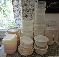 Full lot showing stacked round and square containers, lids, and pitcher