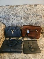 All four leather handbags displayed on sofa