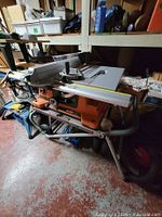 Table saw on folded rolling stand showing overall lot
