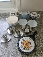 Full group showing teapot, creamer, mixing bowl, mugs, bowls, egg cups and trivet