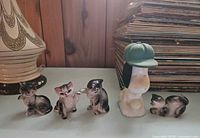 Five figurines lined up showing relative sizes and poses