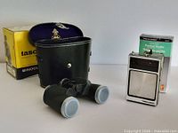 Overall lot showing Tasco binoculars with caps, case and box, plus Realistic pocket radio with case and box
