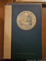 Front cover showing navy cloth, tan spine strip, gilt world map emblem
