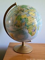 Overall view of the desk globe on brass-tone pedestal base
