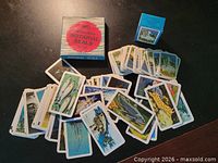 Spread of loose fish picture cards, striped Notarial Seals box, blue souvenir card box