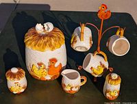 Photo of full set arranged on table showing cookie jar, creamer, sugar bowl, shaker, mugs on tree and loose mugs