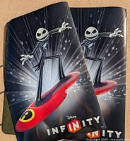 Two promotional Disney Infinity posters featuring Jack Skellington on a red hoverboard, black background with light bursts, text 'Disney INFINITY'.