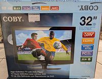 Photo of the retail box showing 32 inch Coby TV with integrated DVD player, highlighting features like HDTV, HDMI input, and multiple video standards supported.
