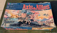 Closed box of 1984 edition Axis & Allies board game showing cover art with military leaders, tanks, planes, and ships.