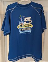 Full front view of blue athletic shirt with Disneyland 5th Half Marathon Weekend design.