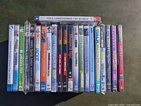 22 factory sealed exercise DVDs arranged side by side, showing titles and colorful covers.