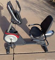 Side view of the black and gray Freemotion 310R recumbent exercise bike with padded seat and handlebars