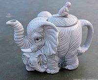 Front-side angle view showing mother elephant body with baby elephant figure and spout.