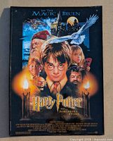 Front side of the Harry Potter and the Sorcerer's Stone poster sign showing the main characters and Hogwarts castle.