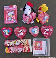 Full overview of all collectible Snoopy Peanuts Valentine items, showing puzzle box, plush toys, heart-shaped containers, candy rolls, and sealed bag.