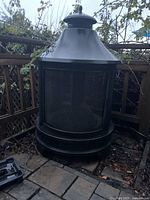 Front view of chiminea showing domed chimney top, mesh body, and base