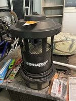 Dynatrap DT17502 electric flying insect trap in black, sitting on a table showing exterior cage design