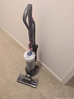 Full front-angle view showing upright vacuum, detachable wand and floor tool on carpet.