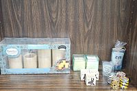 Full assortment including flameless LED candles, two square white candles, a new vodka scented candle in a glass labeled ZYR, three Jamaica themed candles with black silhouette designs, and four animal print votive candles, displayed on a wooden surface.