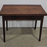 Full front view of mahogany card table showing drawer and flat top surface.