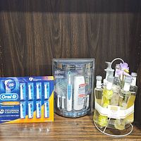 Lot showing all three main items: Braun Oral-B electric toothbrush bonus pack in clear packaging, Oral-B replacement brush heads pack, and spa kit with glass bottles and flowers.