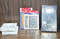 Photo shows all items: greeting cards, calligraphy kit in box, two stationary boxes on wood surface.
