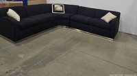 Full view of L-shaped sectional showing all three modules, fabric pattern, metal base trim, and throw pillows