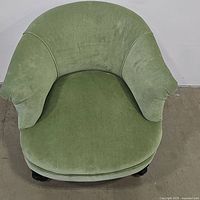 Top view showing the wide, rounded backrest and plush seat cushion upholstered in soft green fabric.