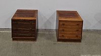Two nightstands side by side; front view of one showing drawers, back of the other