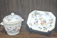 Ice bucket with lid and large platter set displayed on wood surface with floral and gold detailing