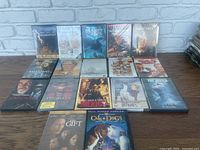 Lot of 17 DVD movie cases arranged in 3 rows showing front cover art of various genres and actors.