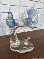 Complete view of the blue and clear glass birds on a clear glass base showing details and conditions including dust and wear.
