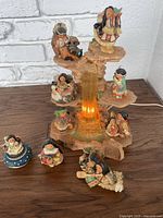 Overall view of the nine figurines arranged on the tiered stand with the illuminated waterfall in the center.