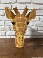 Front view of giraffe head garden statue showing detailed face and coloration