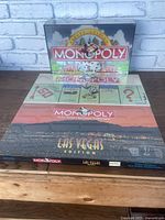 Photo shows Monopoly Las Vegas Edition factory sealed game box with city skyline and themed design visible.