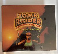 Front view of the sealed Tomb Raider Collectible Card Game box featuring Lara Croft artwork and title.