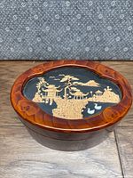 Top view of largest nesting box showcasing cork-carved Asian landscape on lid with pagoda, trees, and ducks