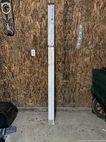 Photo of Oakmont bi-fold door packaged standing vertically against a wood-paneled wall.