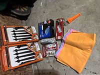 Wide shot showing all items in the lot arranged on the floor including decorative kits, cleaning cloths, screen kits, and scraper