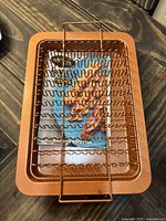 Copper bacon pan with removable wire rack for cooking bacon, shown from above.