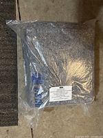 Single folded gray moving blanket sealed in clear plastic with U-Haul and Reuse-Recycle logos in blue visible.