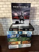 Westworld season 2 DVD box set on top of Lost seasons 1-6 DVD box sets stacked underneath