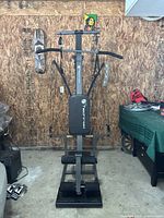 Front view of Techrod TR2 home gym showing padded backrest, resistance bars, and pulley cables.